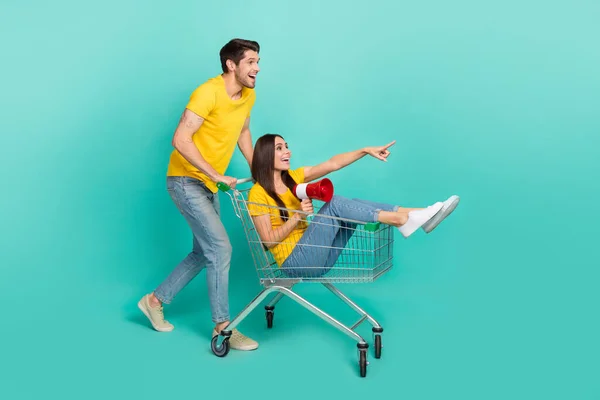 Foto Von Sorglos Aufgeregt Ehepaar Tragen Gelbe Shirts Reiten Einkaufstablett — Stockfoto