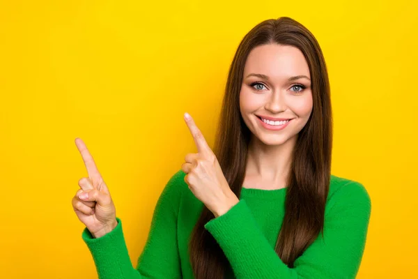 Photo of positive nice lady beaming smile direct fingers empty space isolated on yellow color background.