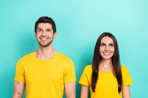 一对年轻夫妇满意地穿着黄色T恤 看上去像在青色背景下孤立的新事件 — 图库照片