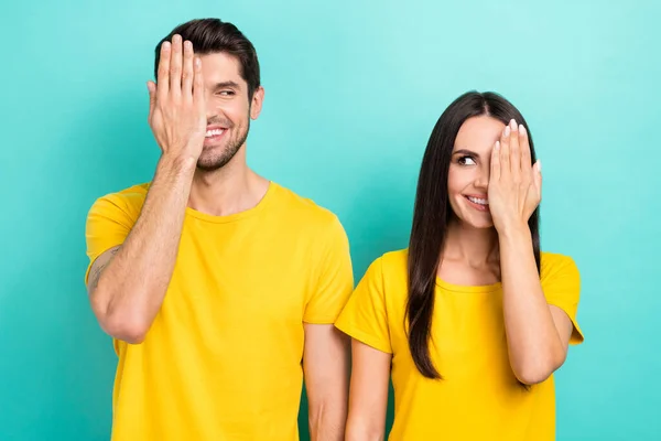 照片上 狡猾害羞的丈夫妻子穿着黄色T恤衫 紧闭双眼 彼此凝视着彼此孤立的蓝绿色背景 — 图库照片