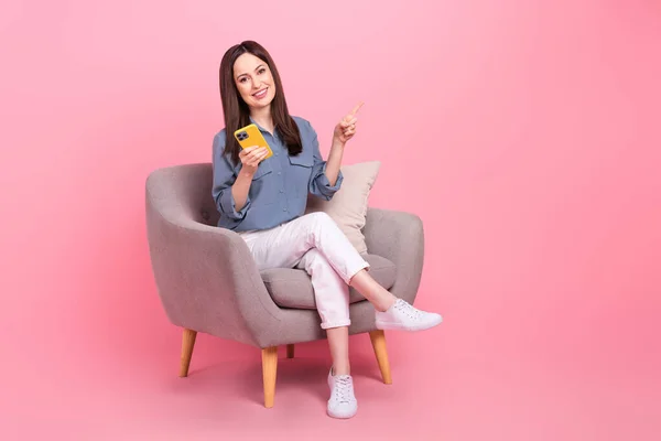 自信のあるマネージャー若い女性のフルボディ写真座っている椅子直接指Mokupホールド電話安いアクセサリー孤立ピンク色の背景 — ストック写真