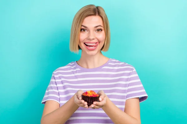 明るい女の子の写真短い髪型ストライプTシャツホールドケーキ舌舐める歯ターコイズ色の背景に隔離 — ストック写真