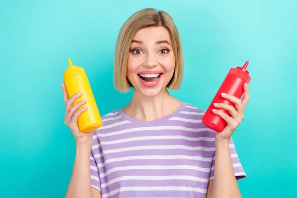 若い面白い女の子の写真を着てトレンディーなTシャツを保持2本のボトルソースは シアン色の背景に隔離された最高の驚きおいしい味を選択します — ストック写真