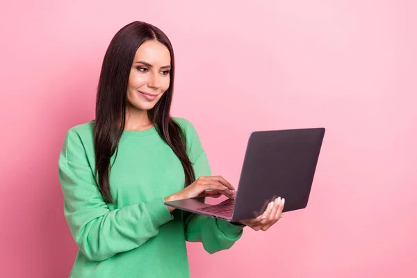満足肯定的な女性の写真ストレートヘアドレス緑のスウェットシャツ書き込み電子メールホールドノートパソコンピンク色の背景に隔離 — ストック写真