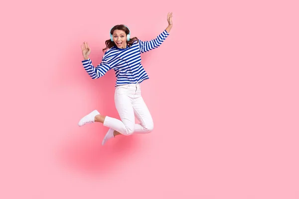 全长跳跃疯狂的照片有乐趣的女人棕色波浪般的头发听耳机苹果音乐广告孤立在粉红色的背景下 — 图库照片