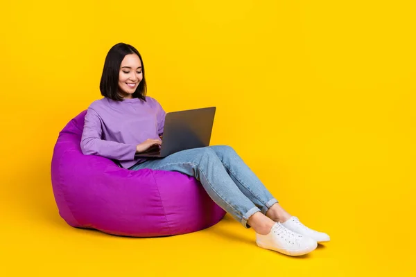 기분좋은 여성의 보라색 셔츠진 신발을 노란색 배경에 고립된 노트북에 — 스톡 사진