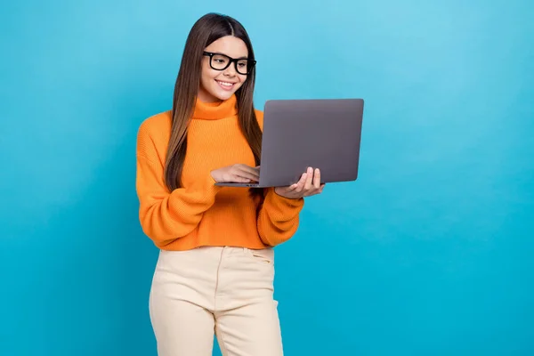 照片上的聪明的好心情的女孩与直发式的橙色毛衣看笔记本电脑聊天孤立的蓝色背景 — 图库照片