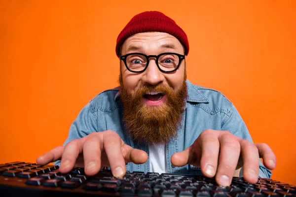 Portrait of excited young guy working on computer typing writing emails letters isolated on bright color background.