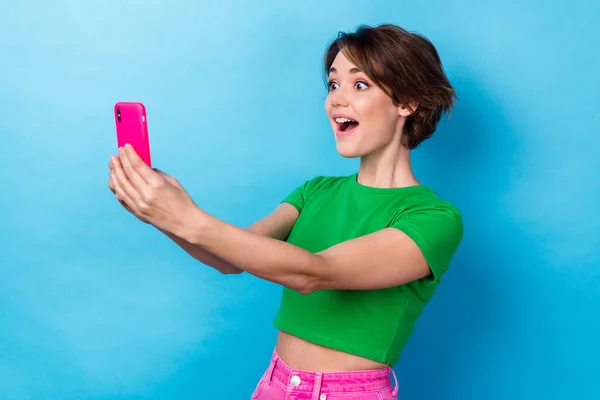 Photo of cute excited lady dressed green top recording video vlog modern device isolated blue color background.