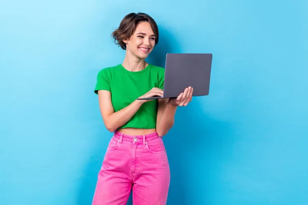 漂亮可爱的女人穿着绿色T恤衫打字电子邮件现代设备隔离蓝色背景的照片 — 图库照片