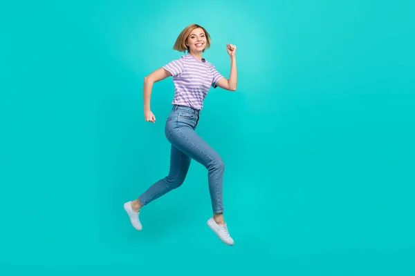 全长照片满意可爱的女孩穿着时髦的T恤衫斜纹棉裤跳跃销售孤立的蓝绿色背景 — 图库照片