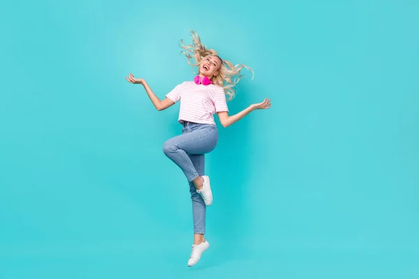 フルサイズ写真のかなり満足女性波毛ストライプTシャツヘッドフォン飛んで笑って孤立した明るいティール色の背景 — ストック写真
