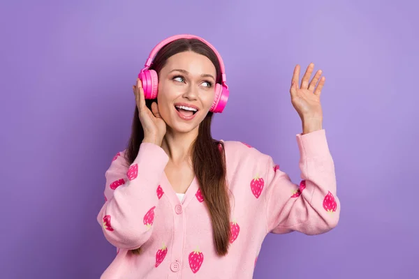 Photo of excited funky lady dressed strawberry print cardigan earphones singing looking empty space isolated purple color background.