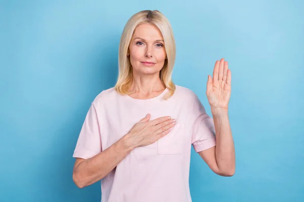 stock image Portrait of kind pleasant pensioner woman bob hairstyle wear white t-shirt arm on chest supporting you isolated on blue color background.