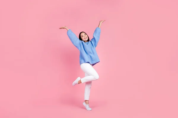 楽しいです女の子の完全な長さの写真は 青いセーター白いパンツ腕は ピンクの色の背景に隔離された空のスペースを実証 — ストック写真