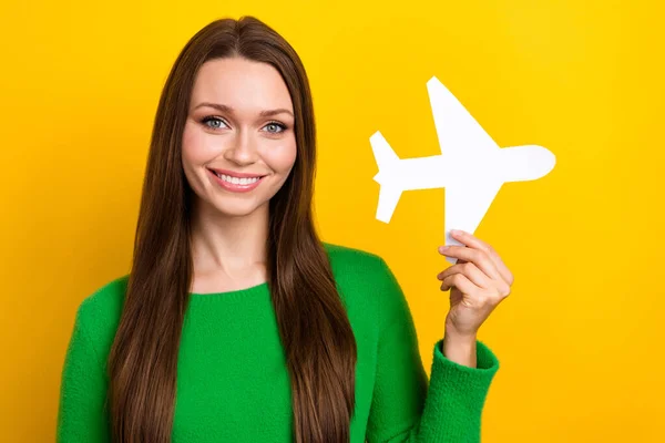 stock image Photo of cheerful cute lady beaming smile arm hold little paper plane isolated on yellow color background.