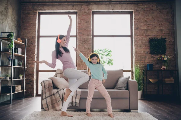 Full length photo of funny family active mom dynamic kid girl listen pop rock music dance on living room house.