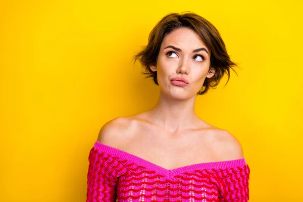 Photo of ponder adorable girl bob hairstyle dressed off shoulder shirt thoughtfully look empty space isolated on yellow color background.