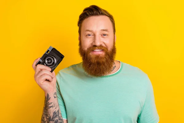若いプロのパパラッチジャーナリストアイルランドの記者ひげ男の写真は 黄色の色の背景に隔離されたレトロな古いカメラを保持Tシャツを着用 — ストック写真