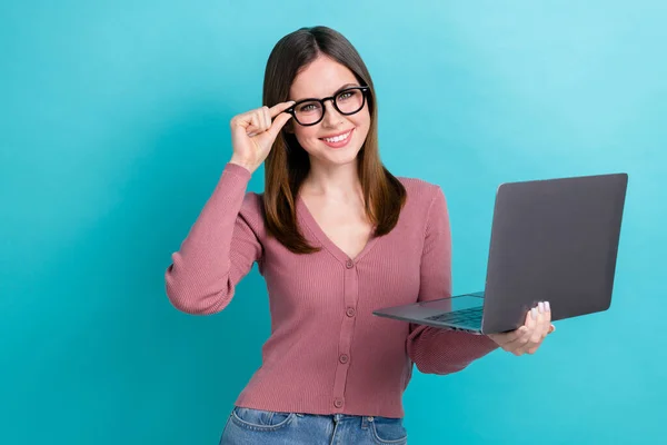 スタイリッシュな髪型と楽観的な満足女性の肖像ピンクのシャツのタッチアイウェアは 青の色の背景に隔離されたノートパソコンを保持 — ストック写真