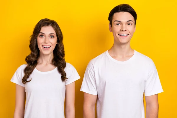 Portrait of excited funny surprised couple girlfriend boyfriend unexpected black friday proposition sale offer isolated on yellow color background.