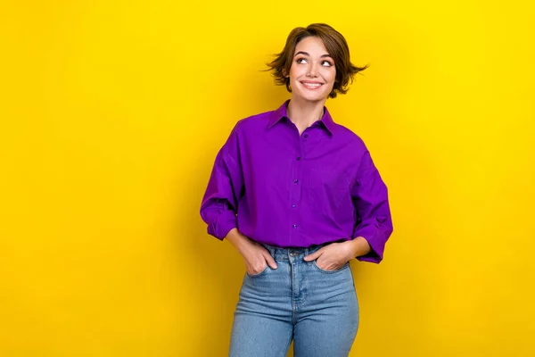 Portrait of attractive broker lady look empty space wear violet blouse hold hands pockets pants isolated yellow color background.
