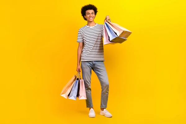 フルボディプロモーション広告写真の若い魅力的な男ホールド店バッグ実証新しい服孤立した黄色の色の背景 — ストック写真