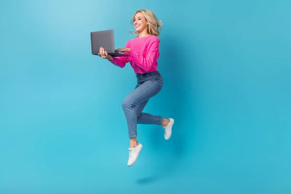 乐观的女士跳着上网本工作遥控器在蓝色背景下独立进行第二部分工作的全景照片 — 图库照片