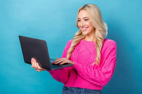 照片中快乐乐观的女孩身穿卷发针织毛衣 阅读邮件时看到的笔记本电脑被蓝色背景隔开了 — 图库照片