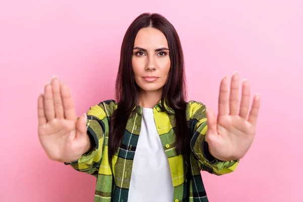 Portrait of focused serious lady hands palms demonstrate stop gesture isolated on pink color background.