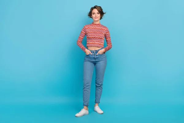 フルサイズ写真愛らしいかわいい女性の腕ポケット良い気分の着用シャツデニムパンツスニーカー隔離された青の色の背景 — ストック写真