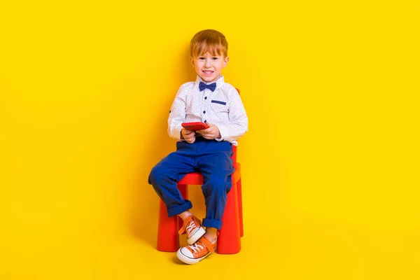 Fotografie Malého Školáka Sedět Školka Židle Pomocí Gadget Textové Spolužáky — Stock fotografie