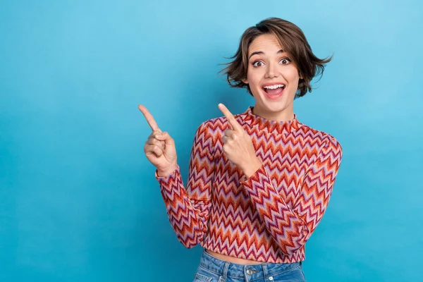Photo of funny excited lady direct index fingers empty space shocking announcement wear print shirt isolated blue color background.