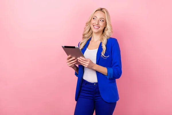 Photo of gorgeous corporate lady hold tablet look empty space isolated on pink color background.