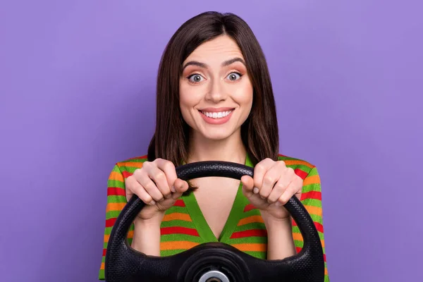 照片上是快乐而积极的漂亮女人 有着直挺挺时髦的发型 手握方向盘 驾驶着被紫色背景隔离的汽车 — 图库照片