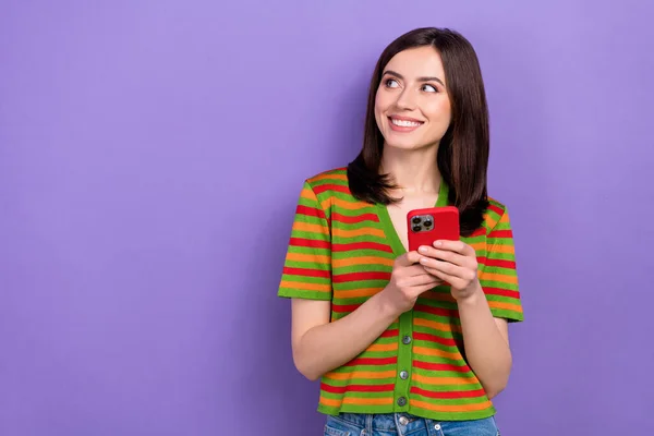 Photo of gorgeous lovely lady stylish striped clothes hold iphone look empty space interesting offer isolated on purple color background.