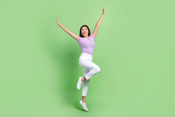 时尚迷人的越南女子跳起舞的全身像 高举双手跳起离奇的节奏 与绿色背景隔离 — 图库照片