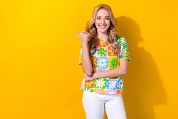若いお店のアシスタント女性の直接指空のスペースポスター着用プリントシャツ白パンツ隔離された黄色の色背景 — ストック写真