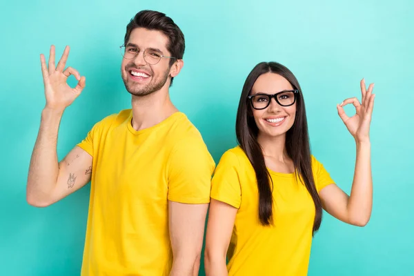 图片说明 两个年轻男子的妻子穿着黄色T恤衫时髦的眼镜 被推荐在蓝色背景下隔离的图书馆 — 图库照片