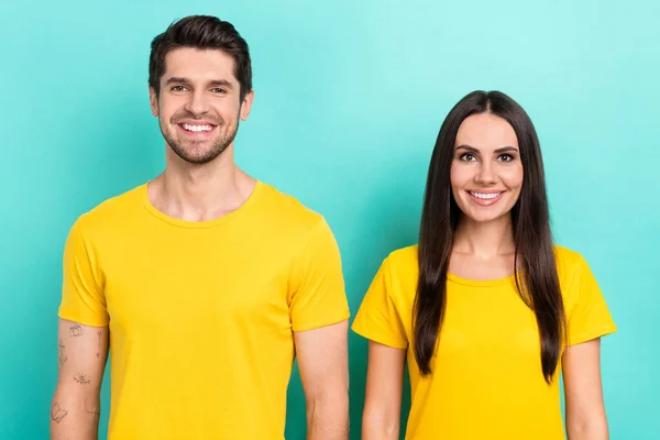 2人の若者の写真の肖像画は アクアマリン色の背景に隔離された男と黄色のTシャツのロゴブルネットの髪の女性陽気な笑顔を身に着けている — ストック写真