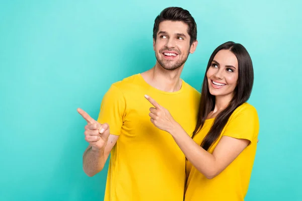 若い素敵なカップルの写真日付一緒に黄色のスタイリッシュなTシャツを着用指の空のスペースを演出シアン色の背景に隔離された感情 — ストック写真