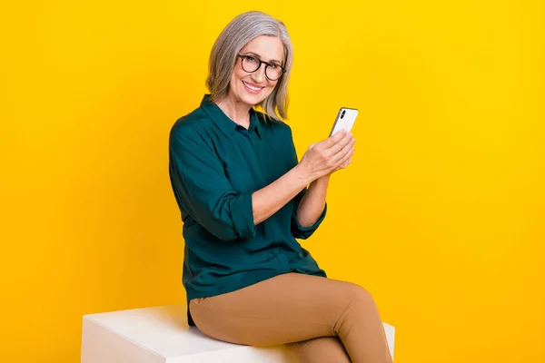 Çekici Kişinin Fotoğrafı Podyumda Otururken Sarı Arkaplanda Izole Edilmiş Telefon — Stok fotoğraf