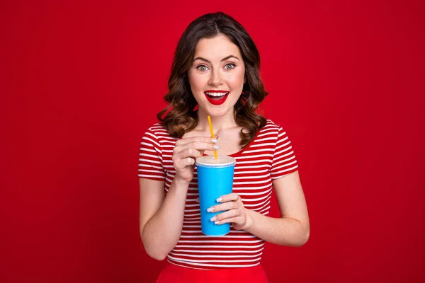 豪華な美しい女性の肖像画スタイリッシュな服を保持紙マグカップ赤の色の背景に隔離された映画を見て甘い飲料を飲む — ストック写真