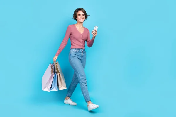 フル長さサイズ写真の若いウォーキング女の子ブログ注文ショッピングホールド掘り出し物プロモーション新しい服孤立した上青色背景 — ストック写真