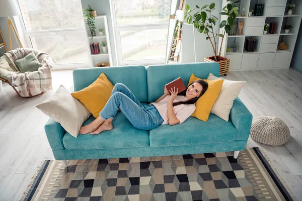 Foto Gadis Ceria Positif Berbaring Nyaman Divan Membaca Buku Kertas — Stok Foto