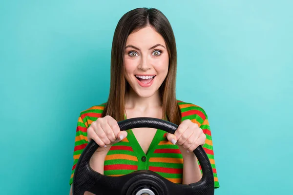 积极兴奋的女士穿着条纹羊毛衫开车隔离的绿松石色背景照片 — 图库照片
