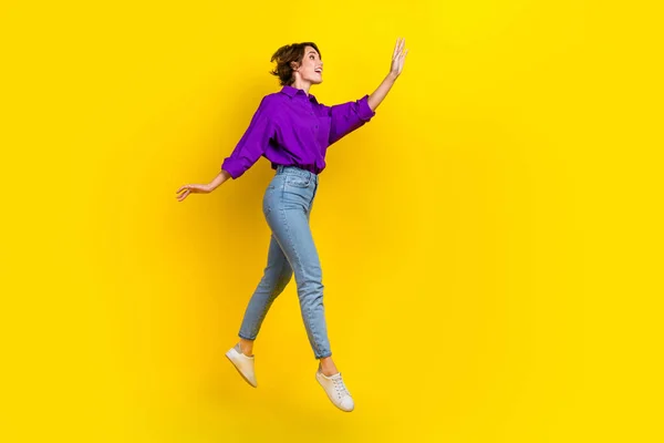 夢のような興奮した女性の完全な長さの写真ドレス紫色のシャツジャンプ腕を振って空のスペース孤立黄色の背景 — ストック写真