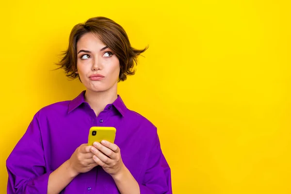 여자가 스마트폰을 노란색 배경에 고립된 공간의 브레인스토밍처럼 보인다 — 스톡 사진