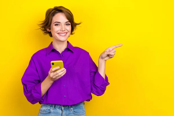 스러운 여성의 자주색 셔츠를 노란색 배경에 고립된 속도의 전화를 — 스톡 사진
