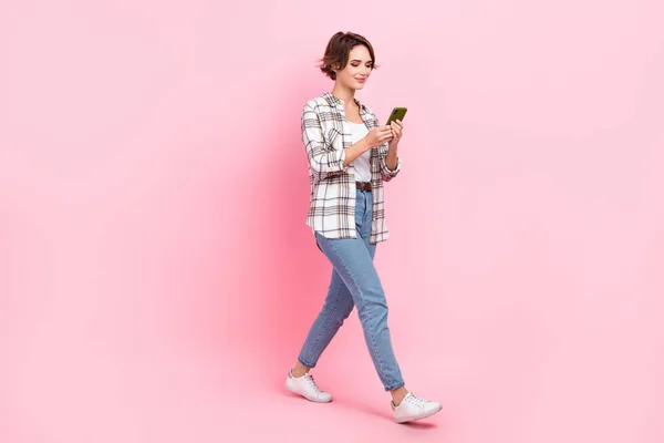 フルボディプロフィール写真のいい正の女性使用スマートフォンタイピングポスト歩行孤立した黄色の色背景 — ストック写真